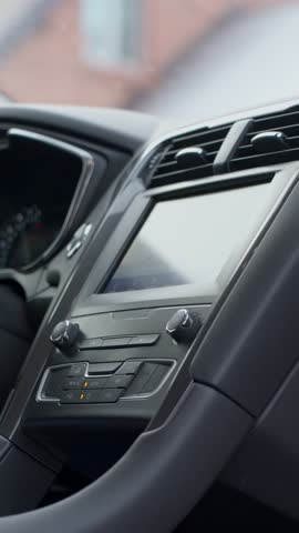 Close up of finger pressing car climate control button on modern vehicle dashboard. Concept of car heating and comfort driving in winter season