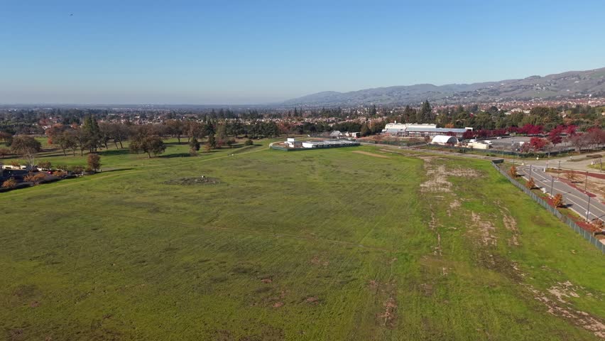 Drone views trace the contours of Yerba Buena Meadows in San Jose, presenting broad vistas of foothills, rooftops, and open areas shaped by afternoon light.