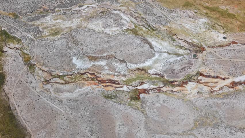 Drone follows river upstream in Peru’s Salinas Lagoon. The barren volcanic landscape is streaked with bright iron and sulfur deposits, highlighting nature’s vibrant minerals in this dramatic Terrain