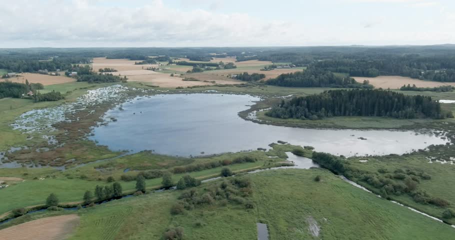 Aerial view of Vanjärvi lake and its surrounding landscape in cloudy summer weather, Vihti, Finland.