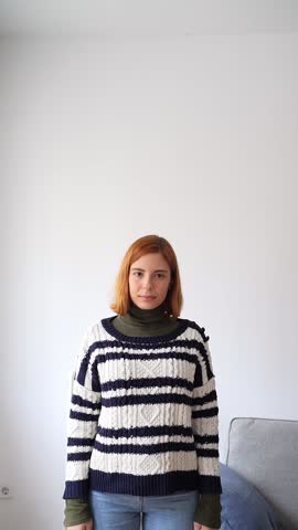 Beautiful redhead woman with a warm smile looking at the camera on a white background