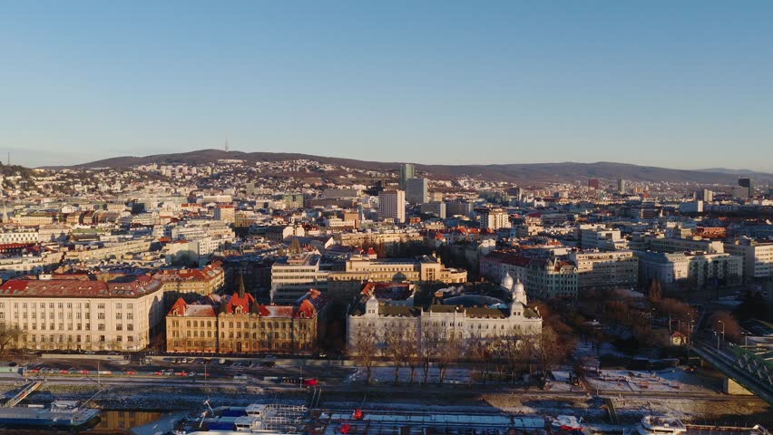 Aerial daytime panorama of Bratislava city with historic buildings, urban districts and surrounding hills. Winter scenery, clear sky and calm European city atmosphere.