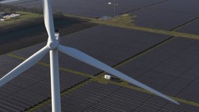 Wind turbine rotating above solar panel farm producing renewable energy - Powered by Shutterstock - Get 15% off with code: PIKWIZARD15
