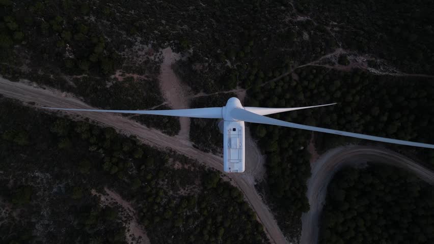 Aerial top down view of wind turbine blades rotating for renewable energy