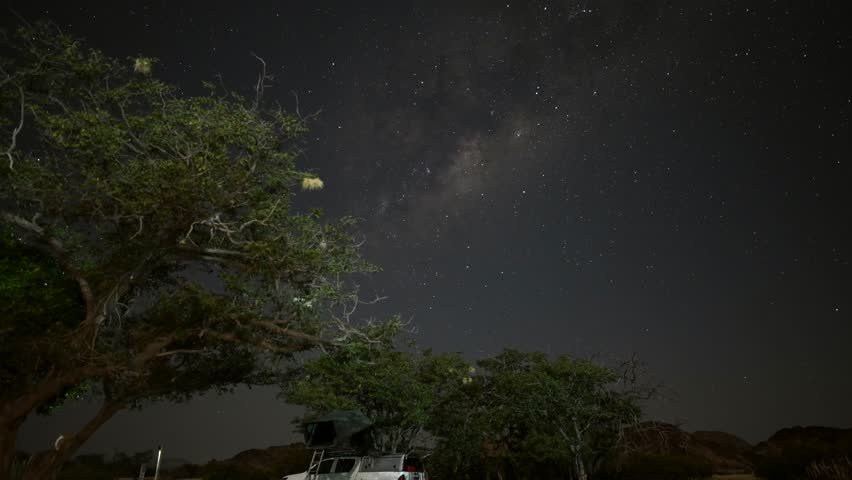 A starry sky stretches over a campsite in Namibia, Africa. Night timelapse