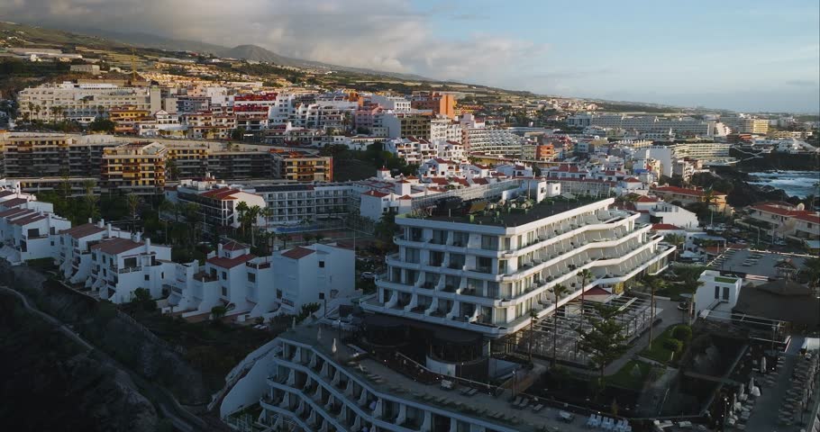 Panoramic vista showcasing the coastal resort of Los Gigantes, Tenerife, with its distinctive hotels and the vast Atlantic Ocean