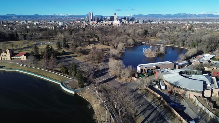 Duck Lake borders northwest side of City Park near Denver Zoo and 23rd Avenue, winding paths and sparse winter foliage. Gray water, dormant grass, long shadows season textures, Denver, Colorado. USA