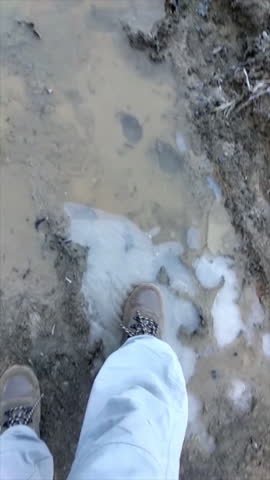 Early morning winter day with the water in the puddles frozen, ice that breaks when we step on it with our boots while hiking