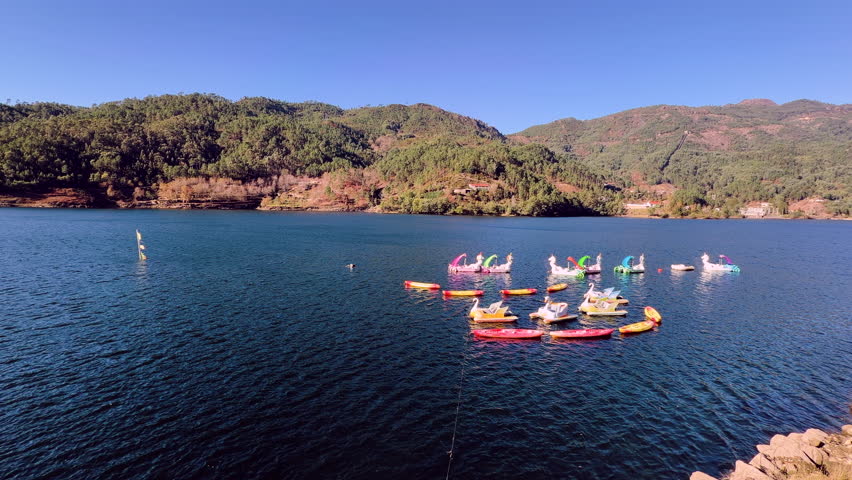 Colorful pedal boats floating on Albufeira da Caniçada reservoir in Terras de Bouro