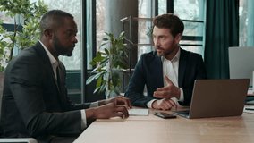 Diverse business team two businessmen Caucasian African American men with laptop documents review in office working colleagues discuss data analyzing stats focused multiracial partners check papers - Powered by Shutterstock - Get 15% off with code: PIKWIZARD15
