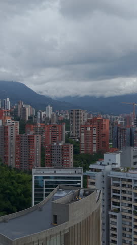 Stunning aerial footage captures the vibrant architecture and lush greenery of El Poblado in Medellín, Colombia. Vertical video ideal for social media, showcasing urban landscapes.