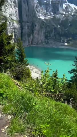 Turquoise Alpine Lake with Snow-Capped Mountains and Forest