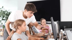 Young guy teacher teaches girl student to work with computer in lesson - Powered by Shutterstock - Get 15% off with code: PIKWIZARD15