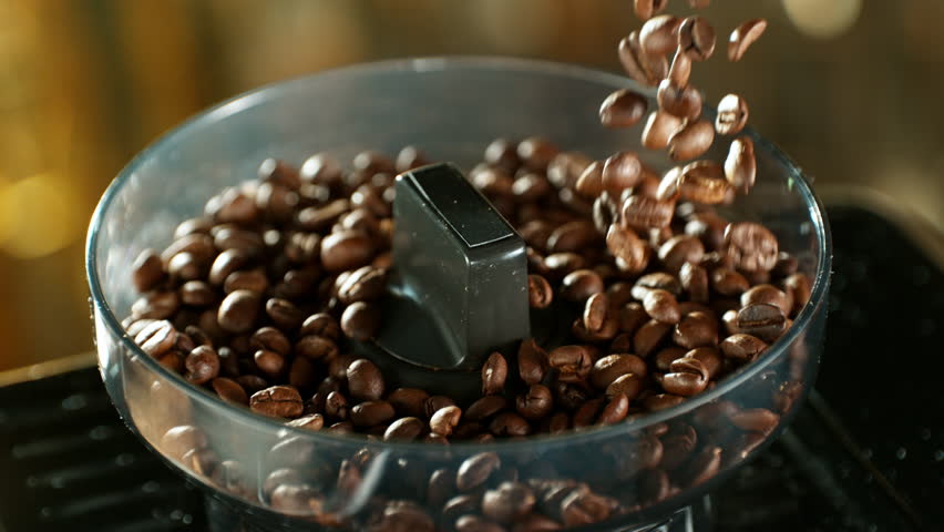 Close-up of Falling Coffee Beans into Grinder , Slow Motion . Filmed on High Speed Cinematic Camera