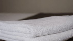 Close-up of hands placing white bath towels on the bed sheet. Concept of room cleaning service. High quality 4k footage - Powered by Shutterstock - Get 15% off with code: PIKWIZARD15