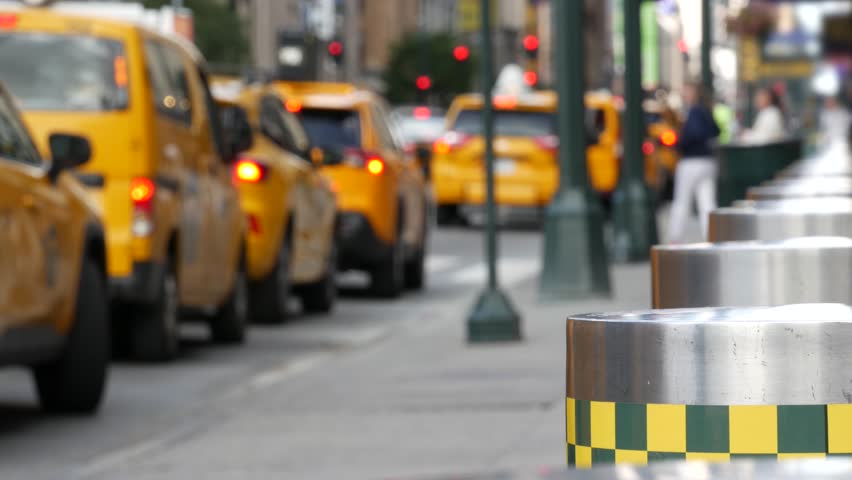 Manhattan Midtown street New York City, United States. Defocused row of yellow taxi cars. Many taxi cabs in line on 8th avenue near Penn Station. Taxi queue, urban road traffic, passenger transport.