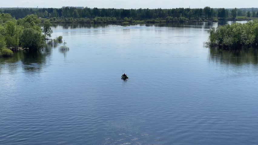 A fisherman is fishing in the middle of the river in a boat
