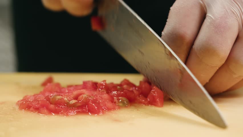 Chop tomato close up, Diced tomatoes on a cutting board for Italian sauce, chef cut tomatoes with knife. 