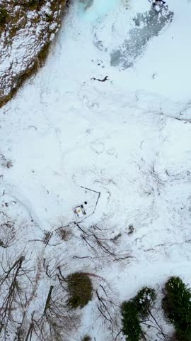 Raccolana Valley and the Fontanone di Goriuda waterfall in the snow in winter. Vertical shot.