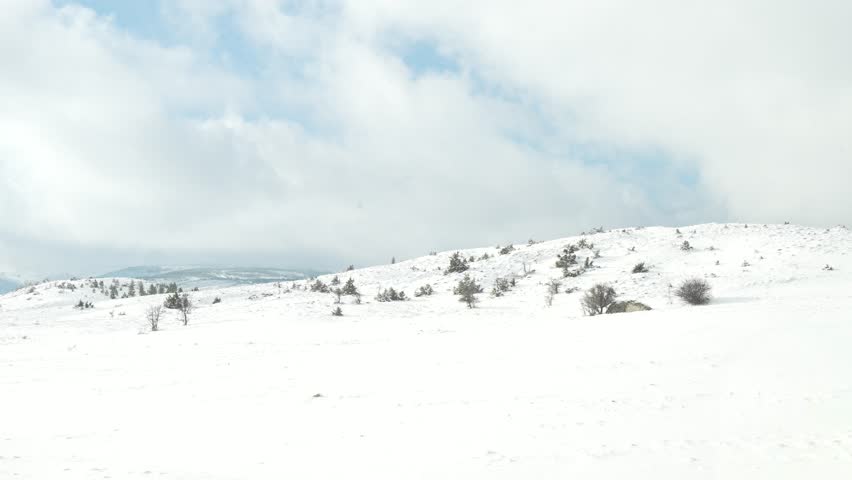 Snow-covered winter landscape filmed with a camera, featuring frozen ground, white terrain, and cold seasonal atmosphere. Natural winter scenery with soft light and minimal elements, suitable for nature backgrounds, climate and weather concepts, outdoor visuals, seasonal projects, and environmental footage.