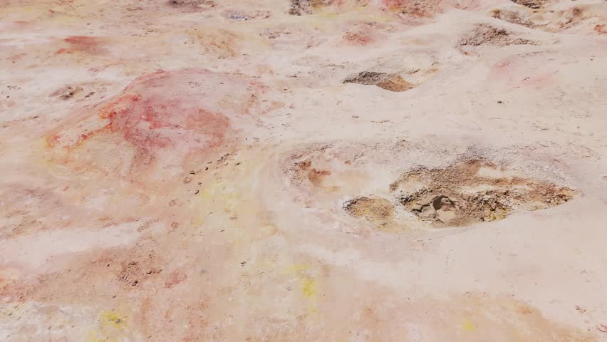 Aerial view of the expansive salt flats in Bolivia, capturing the stark beauty of the landscape with dust clouds rising from the ground