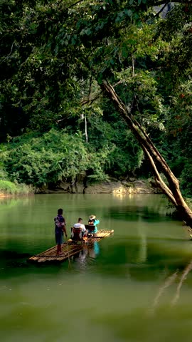 Experience the serene beauty of Khao Sok, Thailand, as local guides navigate a bamboo raft through lush greenery. Natural wonders and vibrant wildlife create a peaceful escape in the heart of nature.
