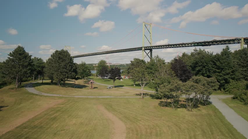Drone Footage Captures The Mackay Bridge Linking Halifax And Dartmouth Nova Scotia Canada Under Bright Summer Sun With Blue Water Clean Lines And Light Traffic Forming A Stunning Transport Landscape