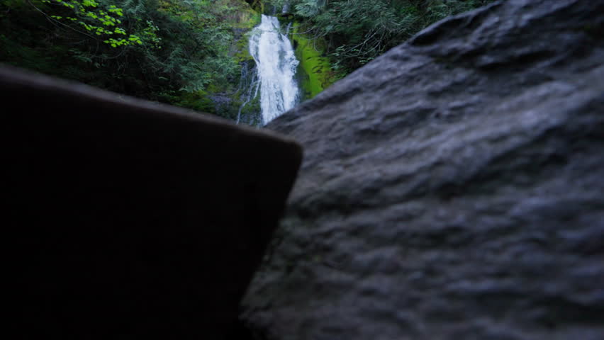 Waterfall in Olympic National Park, Washington, cascading through lush forest and moss-covered rocks. Scenic, tranquil nature ideal for travel and landscape footage