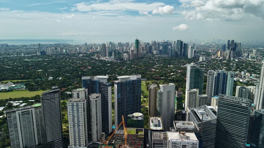 Expansive aerial footage captures Bonifacio Global City from an elevated vantage point, showcasing Manila