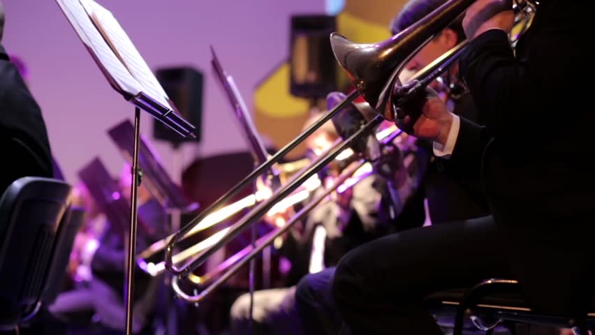 Brass band performing live outdoors, playing instruments with energy and harmony, showcasing music, entertainment, culture, and festive atmosphere.
