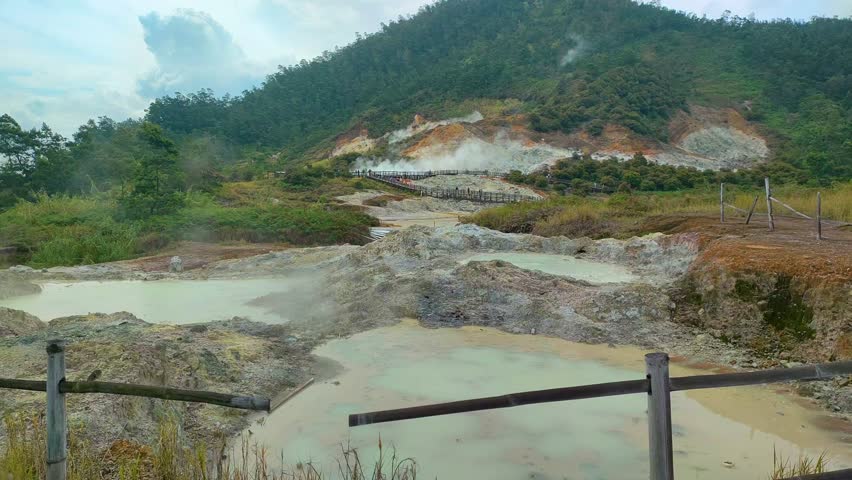 active geothermal activity in the form of hot mud eruptions, thick clouds of sulfur smoke, and colorful hot water pools that emit dangerous gases