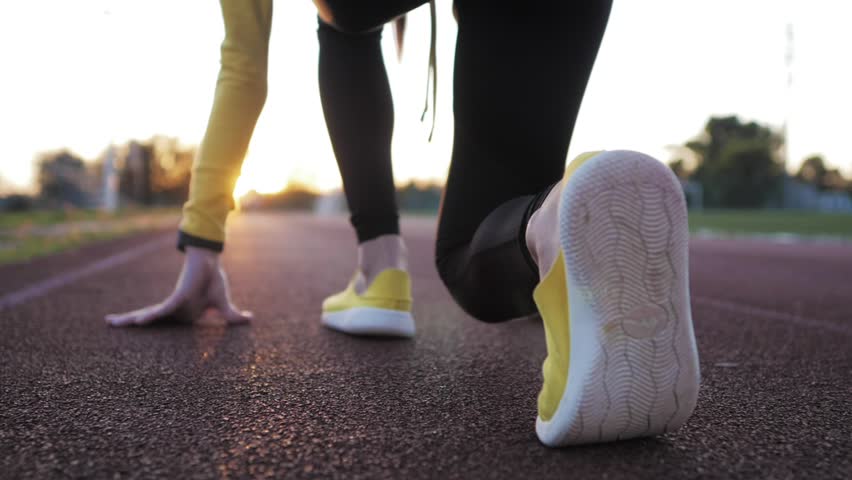 Close-up of women’s legs running on an outdoor track, capturing athletic motion, speed, and fitness training in dynamic action.