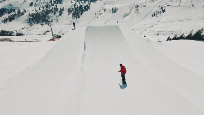 Snowboarder rides down snowy slopes at a ski resort, capturing winter sports, adventure, adrenaline, and scenic alpine landscapes.