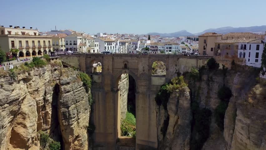 Aerial view of the famous bridge over a deep gorge in Ronda, Spain with historic buildings.