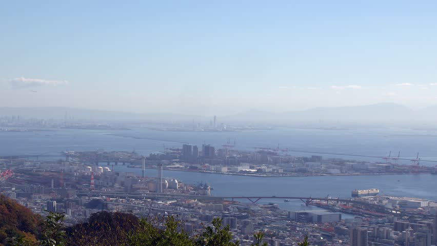 View of waterfront skyline in Kobe Japan with Osaka in distance, sky