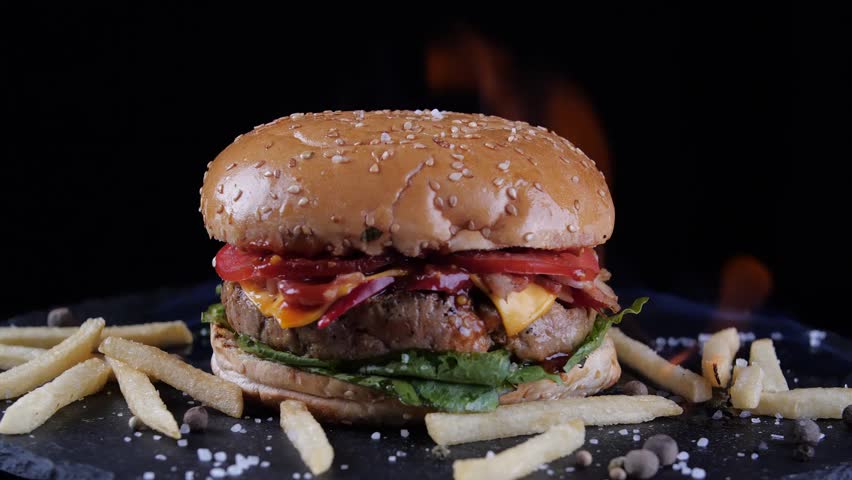 Gourmet beef burger served with french fries on plate. Ideal for fast food advertising, restaurant promotion, and menu visuals.