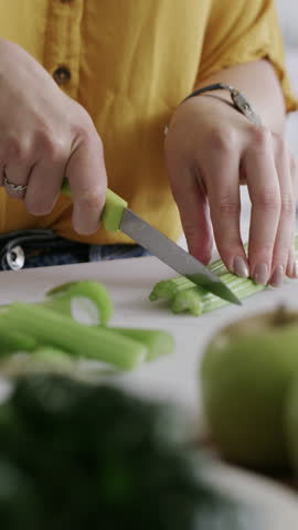 Knife, hands and woman cutting celery in kitchen for cooking, meal or diet snack in morning. Ingredients, health and female person chopping fresh vegetables for nutrition supper or dinner in house.