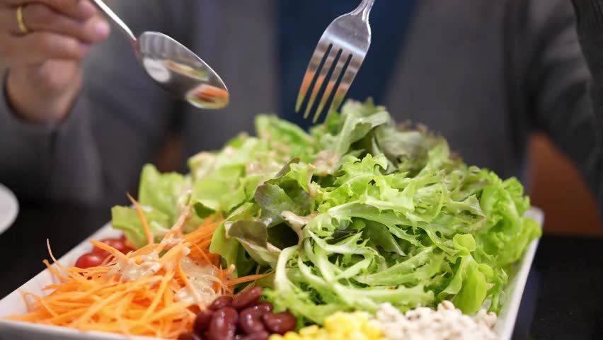 Close-up of Person Tossing and Eating Large Garden Salad