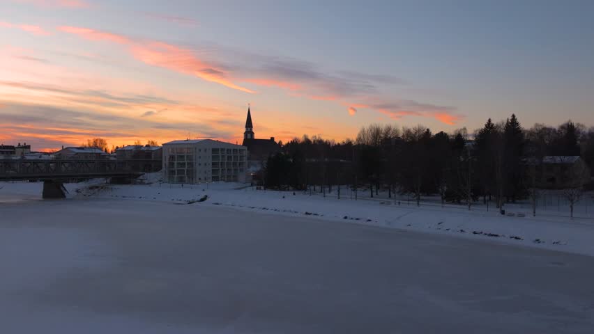 4K cinematic drone footage of Rovaniemi Church (Rovaniemen kirkko) in Finland during golden hour at the winter solstice, showcasing the Nordic church architecture surrounded by snow_71
