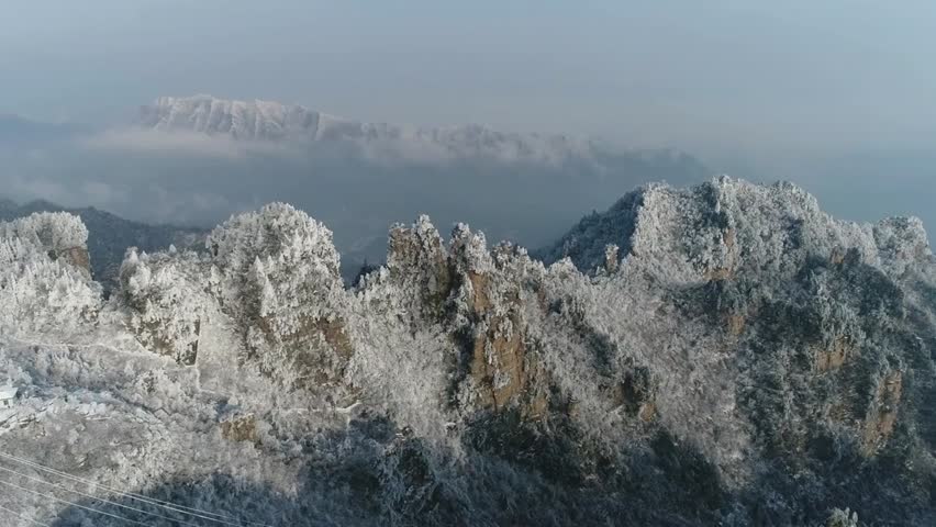 Snow-covered mountains in winter with frost and ice on the trees, creating a serene, cold, and scenic winter landscape in nature.