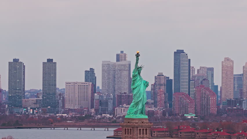 Liberty monument. New York City skyline. Liberty statue before New York City skyline. New York City landmark with Liberty monument. Liberty statue and New York City skyscrapers.