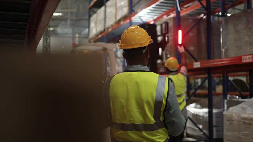 Blue collar workers are working at warehouse. Logistics, transportation.