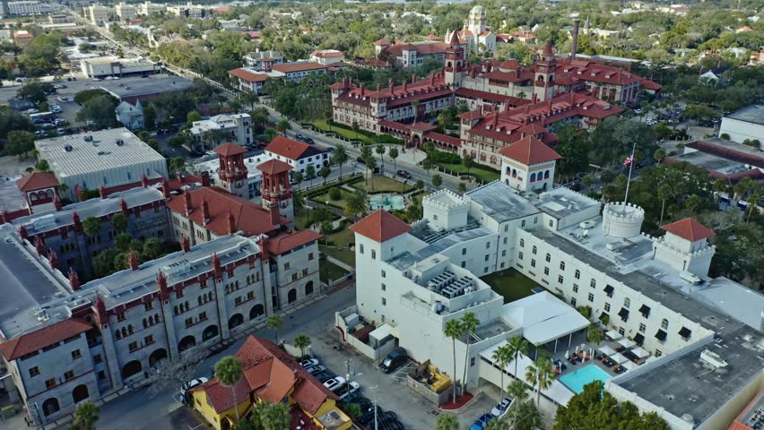 Flagler College in St. Augustine, Florida, showcases historic Spanish Renaissance architecture including castle-like structures and red tiled roofs surrounded by urban greenery and streets.