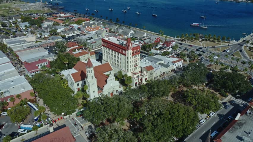 Historic buildings and a waterfront area with boats anchored along the coast are seen in downtown St Augustine, Florida, showing urban and natural elements meeting at the shore.