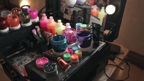 Glitter party makeup station at a birthday event displays colorful pigments, shimmer powders, brushes, and cosmetic bottles arranged for creative face art, festive beauty styling, dolly in shot - Powered by Shutterstock - Get 15% off with code: PIKWIZARD15