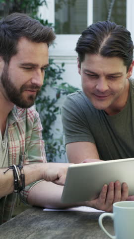 Gay couple, tablet and planning budget in backyard for mortgage, investment or insurance cost. Men, technology or discussion for home finance with savings, bills or asset management with lgbtq people