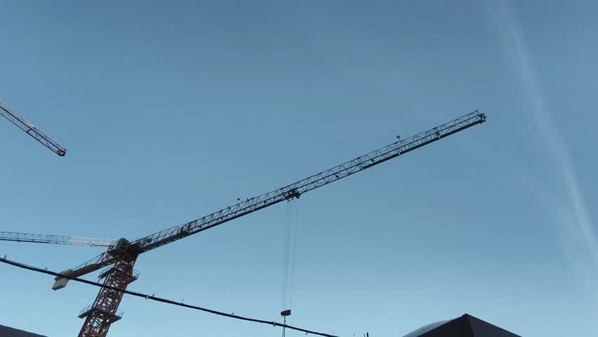 Construction cranes against a blue sky