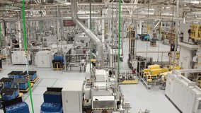 Wide view of a modern automated factory floor with machinery, conveyors, and overhead piping in a clean industrial facility, showcasing smart manufacturing and robotics. - Powered by Shutterstock - Get 15% off with code: PIKWIZARD15