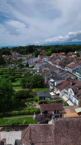 Rooftop view of the city of Rolle, Switzerland, aerial drone vertical video Swiss urban