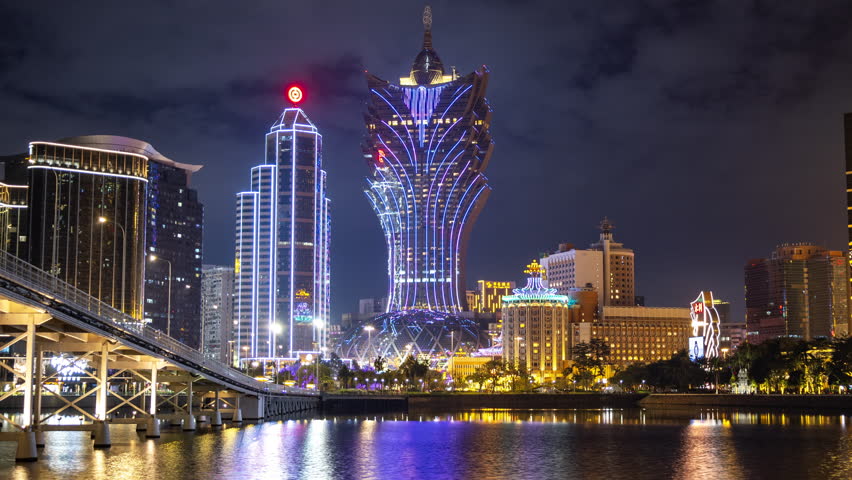 timelapse of the amazing macau casino skyline at night with light reflections in the sea